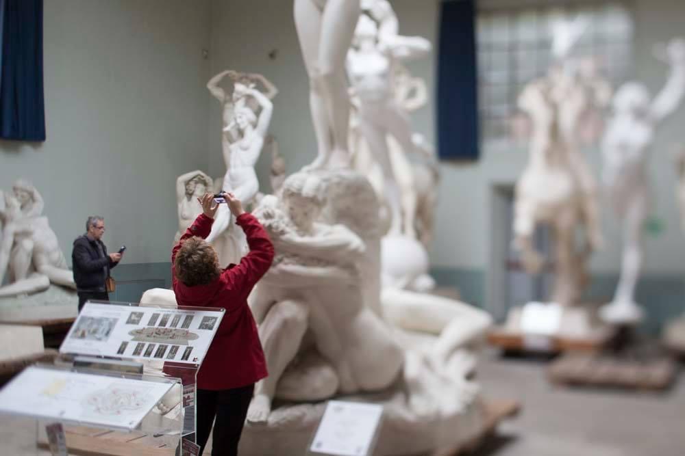 Visitatore fotografa una scultura nel Museo Hendrik Christian Andersen una grande scultura nella sala di un museo