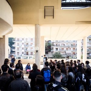 gruppo di studenti che ascolta la spiegazione di una guida nell’atrio di un edificio